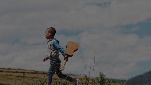 A kid holding ukulele running